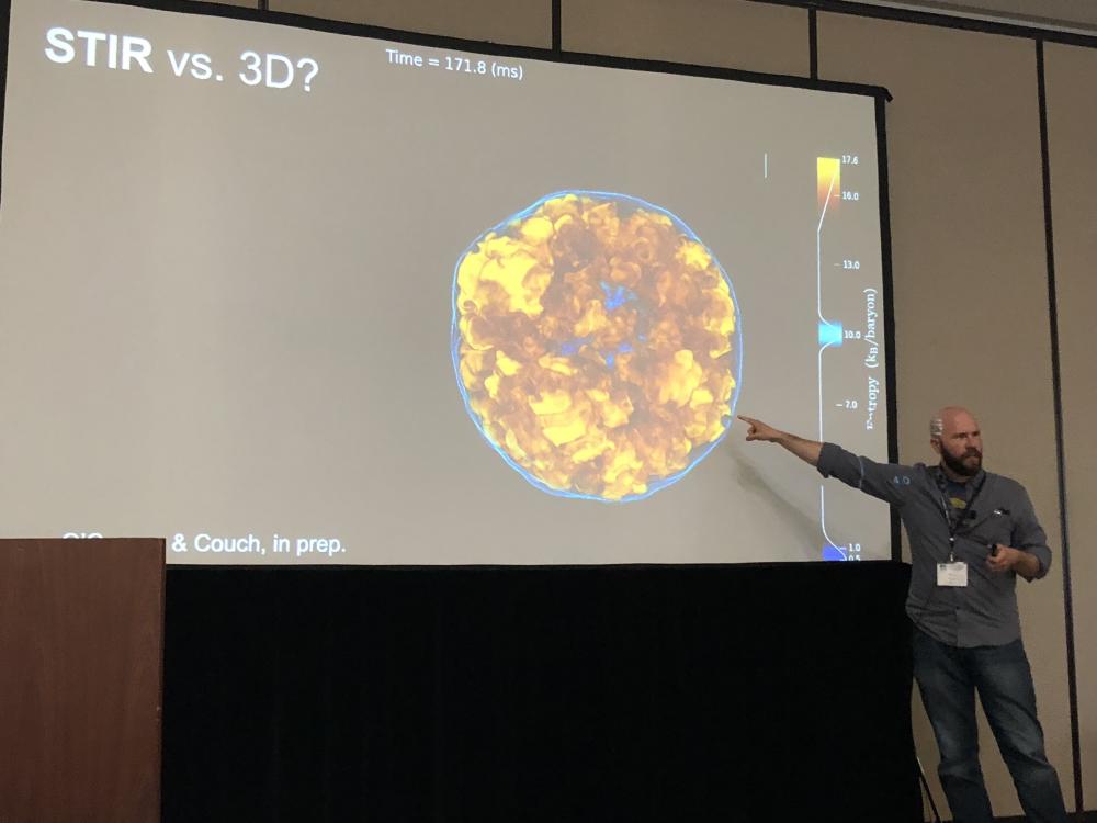 A lecturer pointing to an astrophysics slide